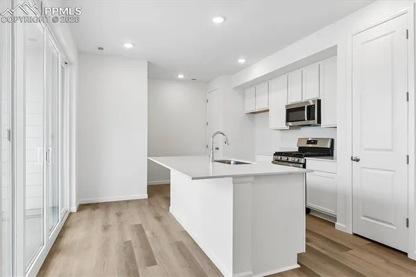 a kitchen with kitchen island a sink stainless steel appliances and cabinets