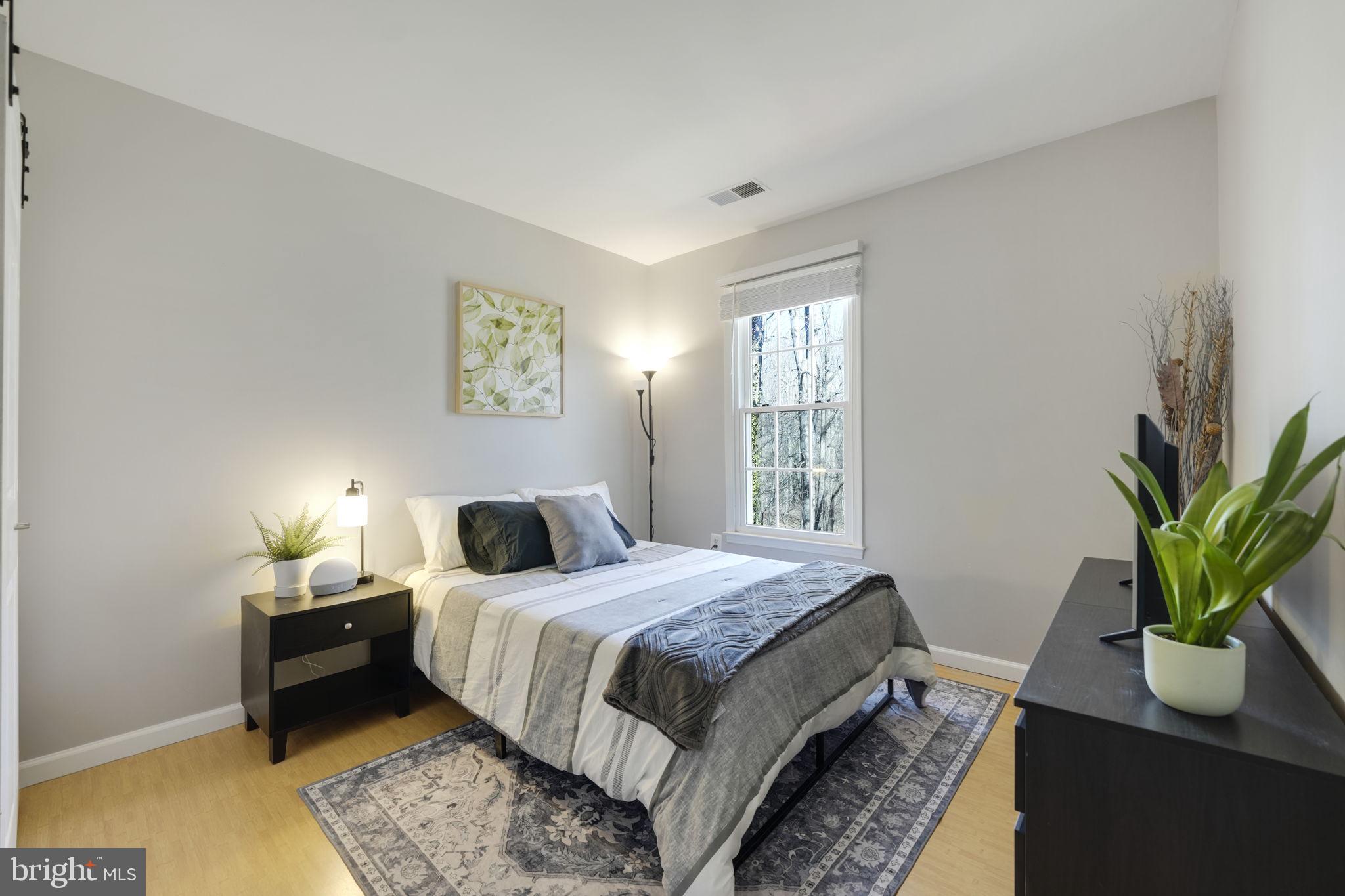 2310 Horseferry Court Reston, VA 20191 - Photo 28 of 49 a bedroom with a bed table and a potted plant