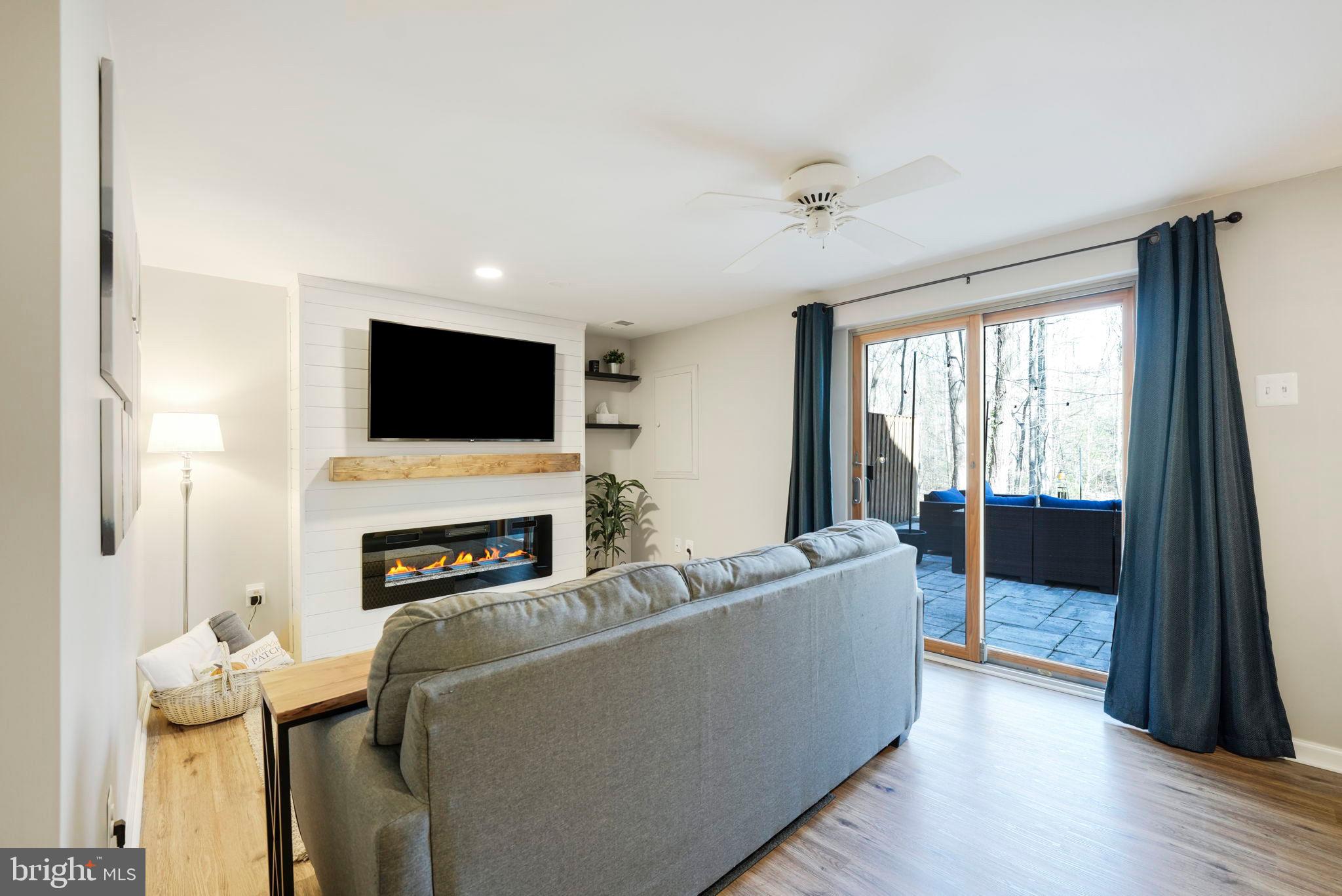 2310 Horseferry Court Reston, VA 20191 - Photo 37 of 49 a living room with furniture a fireplace and a flat screen tv