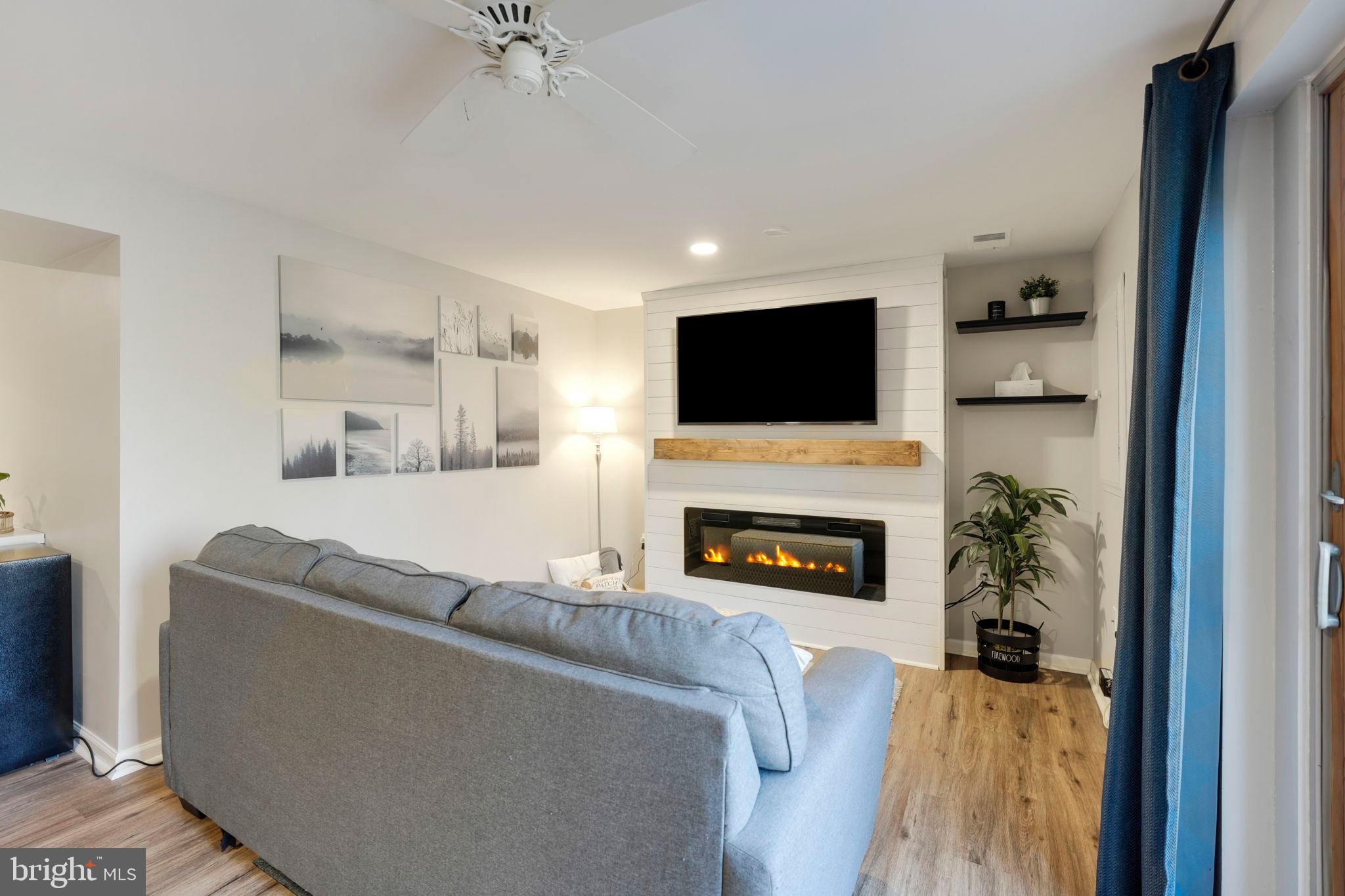 2310 Horseferry Court Reston, VA 20191 - Photo 38 of 49 a living room with furniture a fireplace and a flat screen tv