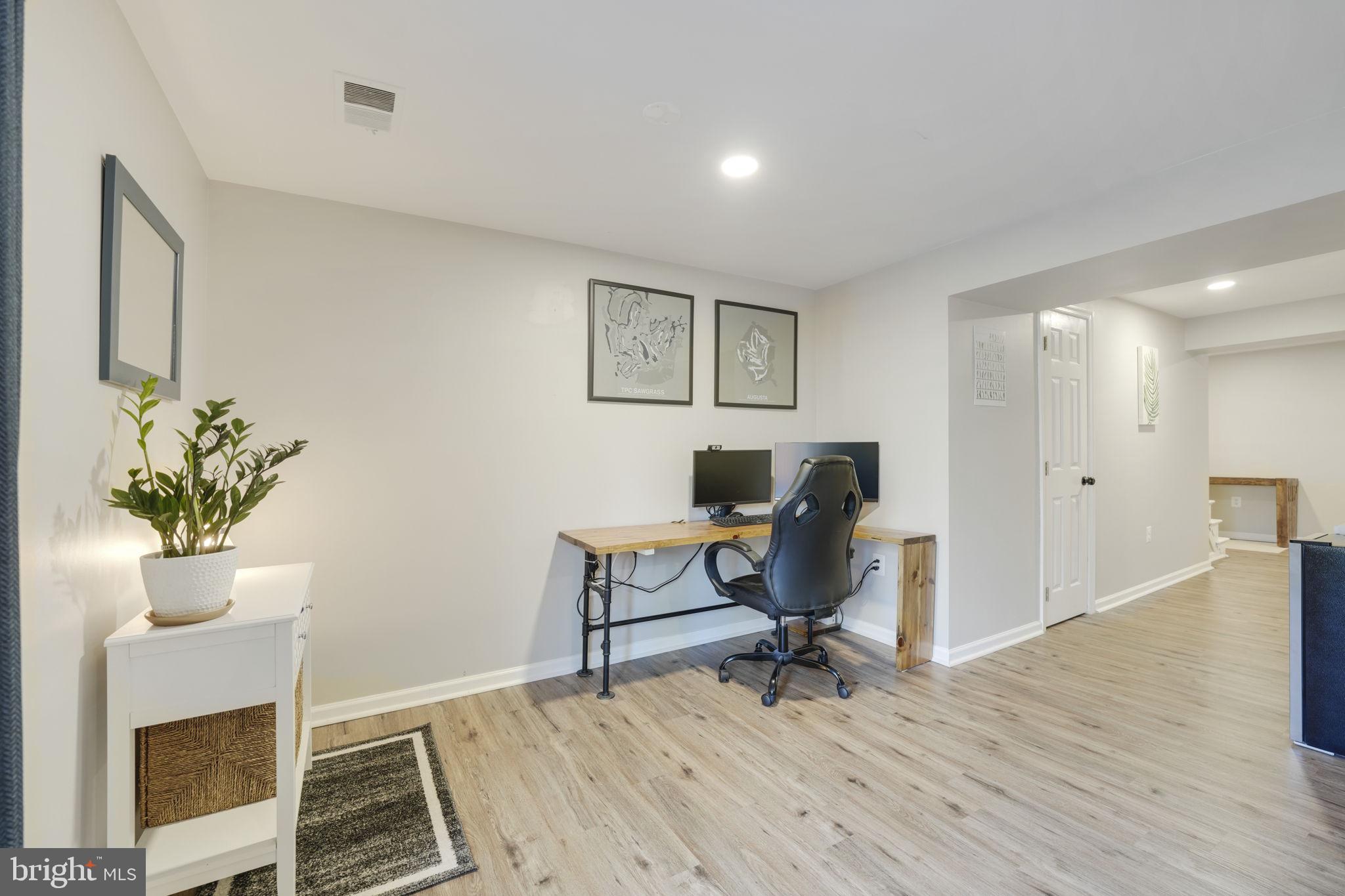2310 Horseferry Court Reston, VA 20191 - Photo 39 of 49 a view of a workspace with wooden floor and a potted plant