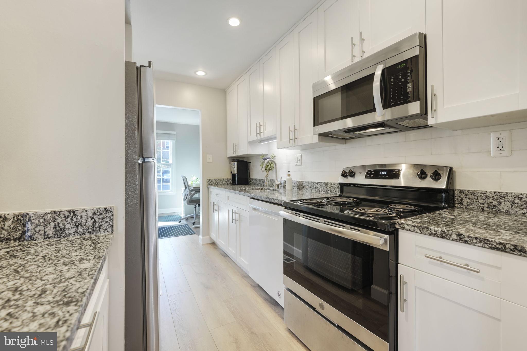 2310 Horseferry Court Reston, VA 20191 - Photo 6 of 49 a kitchen with stainless steel appliances granite countertop a stove top oven microwave and cabinets