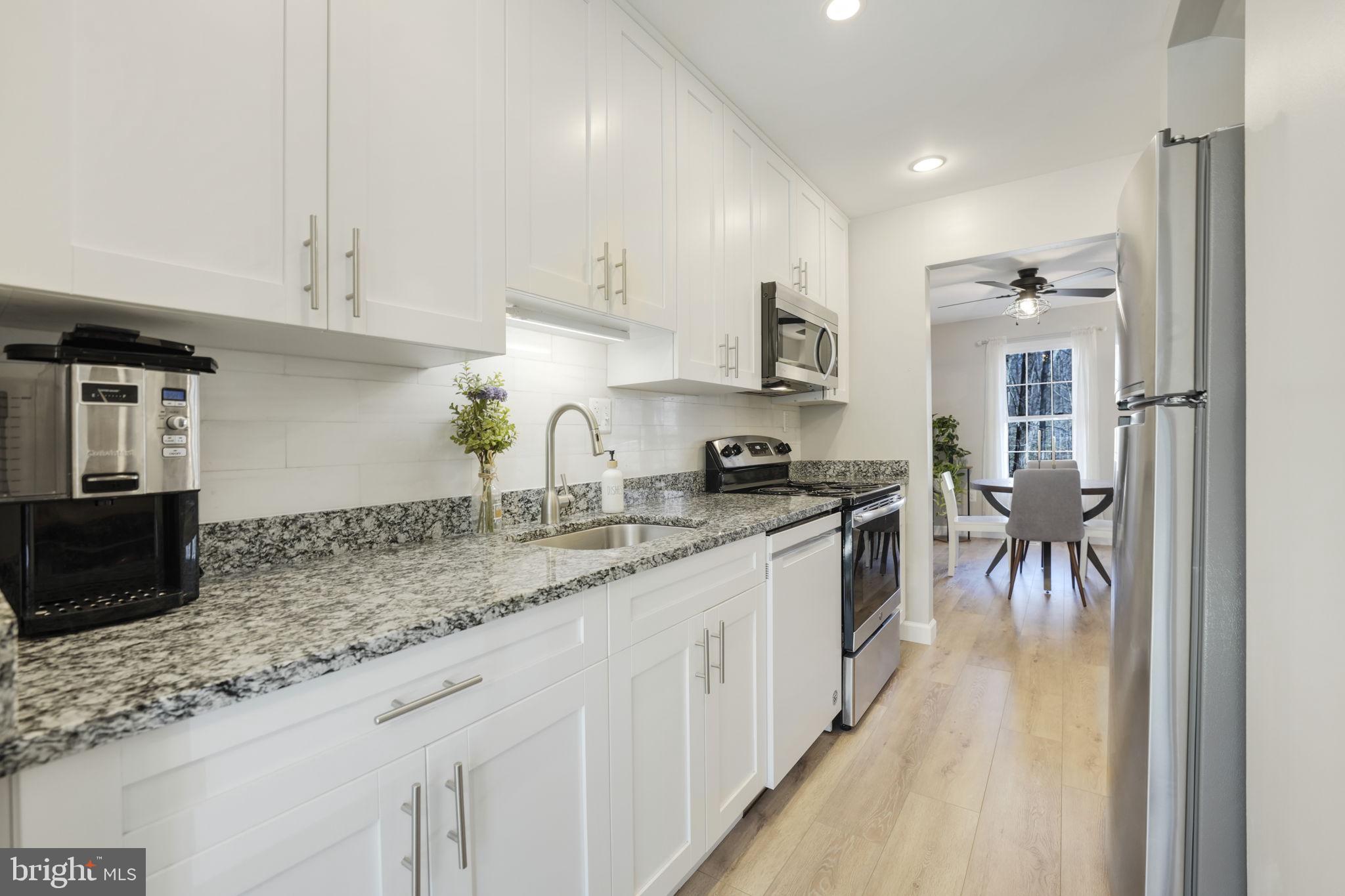 2310 Horseferry Court Reston, VA 20191 - Photo 7 of 49 a kitchen with granite countertop a sink a counter top space stainless steel appliances and cabinets