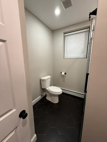 a white toilet sitting next to a bathroom sink and a mirror