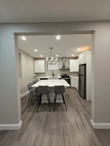 a open kitchen with stainless steel appliances refrigerator dining table and chairs