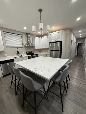 a kitchen with kitchen island a dining table chairs and wooden floor