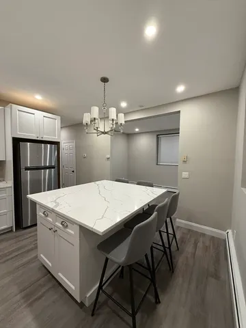 a large kitchen with sink a refrigerator and wooden floor