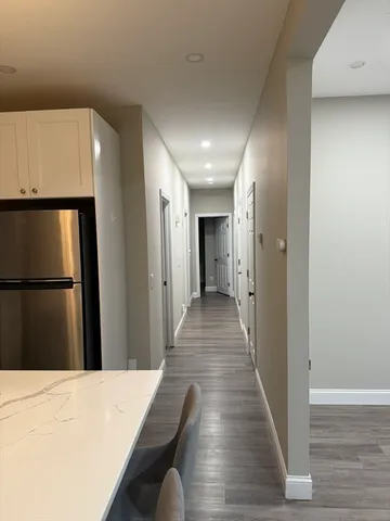 a view of a hallway with wooden floor and staircase