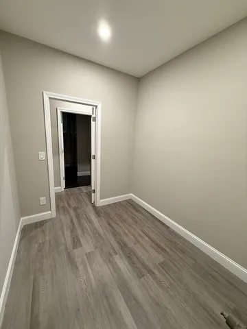 an empty room with wooden floor and closet