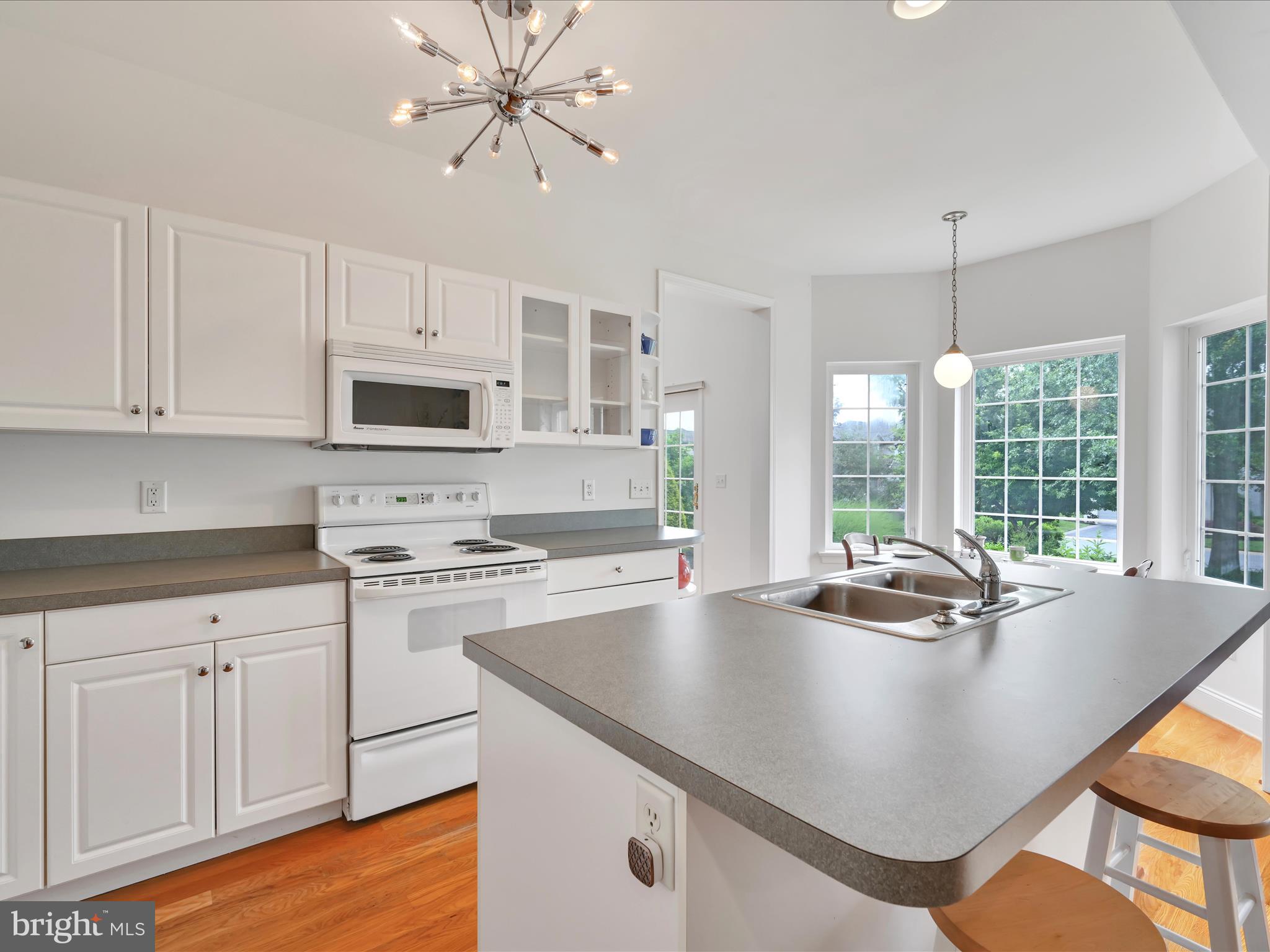 1082 Stillwood Circle Lititz, PA 17543 - Photo 13 of 44 a kitchen with kitchen island a stove a sink a dining table and chairs