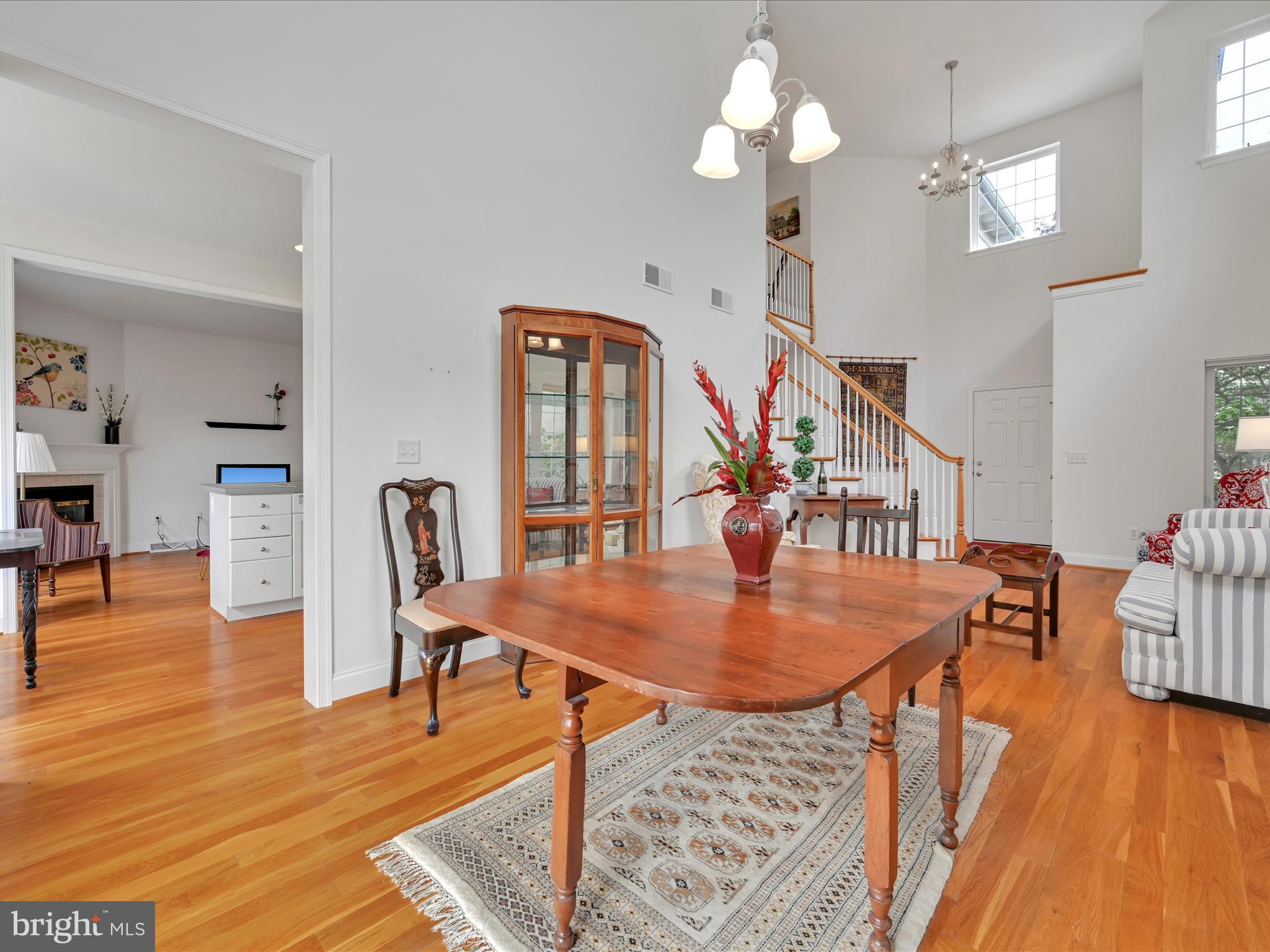 1082 Stillwood Circle Lititz, PA 17543 - Photo 10 of 44 a dining room with wooden floor a chandelier a wooden table and chairs