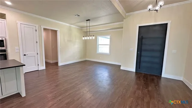 an empty room with wooden floor fireplace and windows