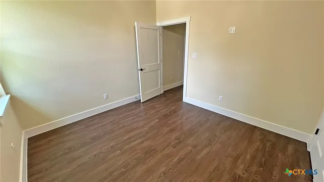a kitchen with granite countertop white cabinets and wooden floor