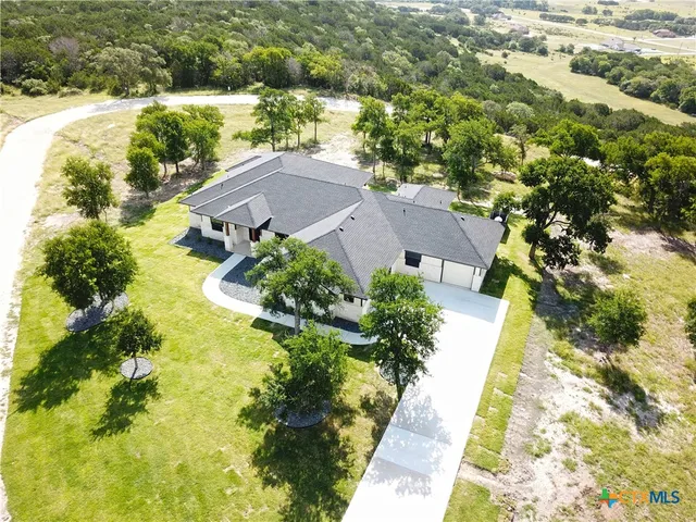 a aerial view of a house with a garden and lake view
