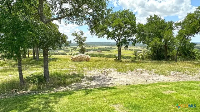 a kitchen with stainless steel appliances granite countertop a refrigerator a sink a stove and white cabinets with wooden floor