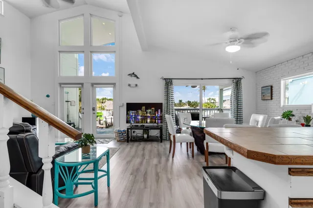a living room with furniture a large window and wooden floor