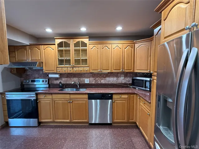 a kitchen with stainless steel appliances granite countertop a stove a sink and a refrigerator