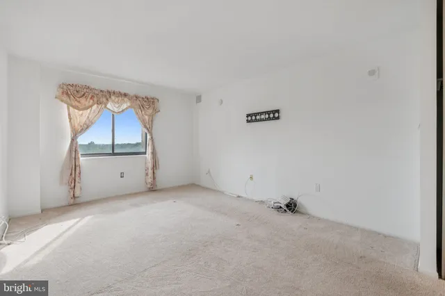 an empty room with a cabinet and mirror