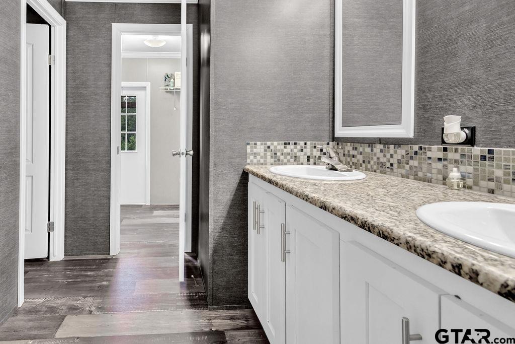 636 Roberson Road Hallsville, TX 75650 - Photo 28 of 46 a bathroom with a granite countertop sink and a mirror