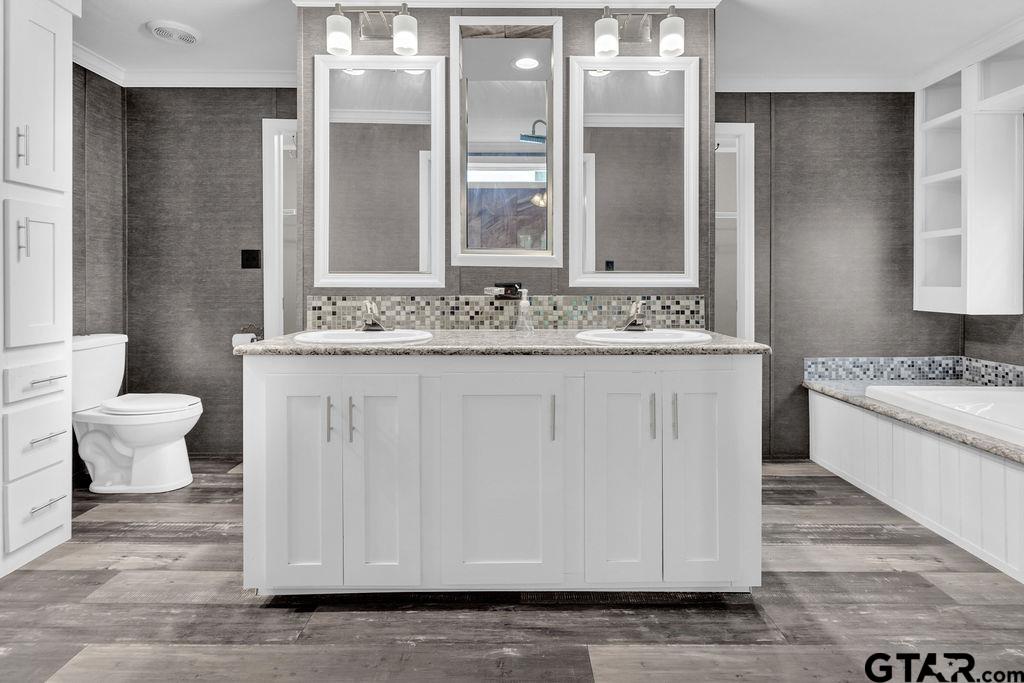 636 Roberson Road Hallsville, TX 75650 - Photo 38 of 46 a bathroom with a granite countertop sink a toilet and a mirror