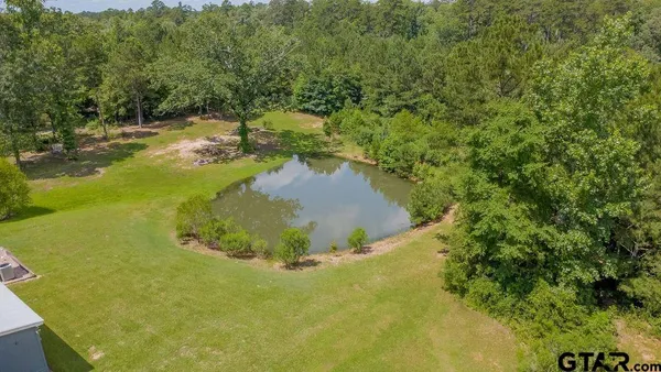 an aerial view of a house with a yard and lake view