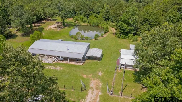 an aerial view of a residential houses with yard