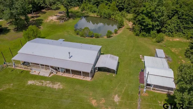 a view of a house with a big yard and large trees