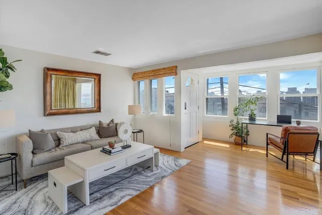a living room with furniture and a table with wooden floor