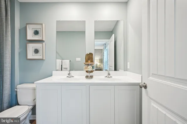 a view of bathroom with a sink toilet and mirror