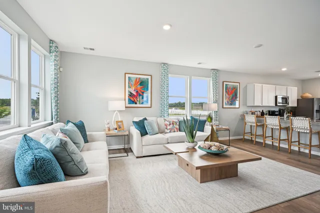 a living room with furniture kitchen view and a large window