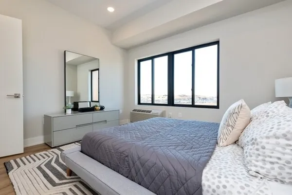 a bedroom with a large bed and a large window