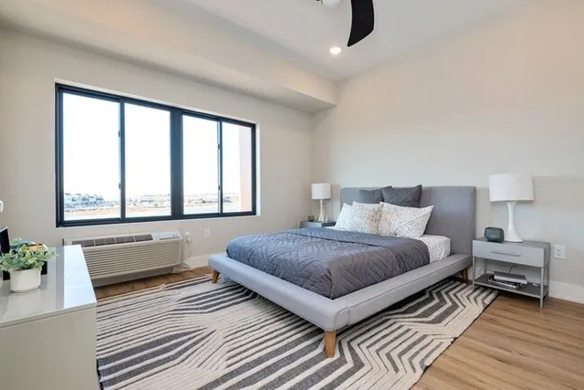 a bedroom with a bed and a large window