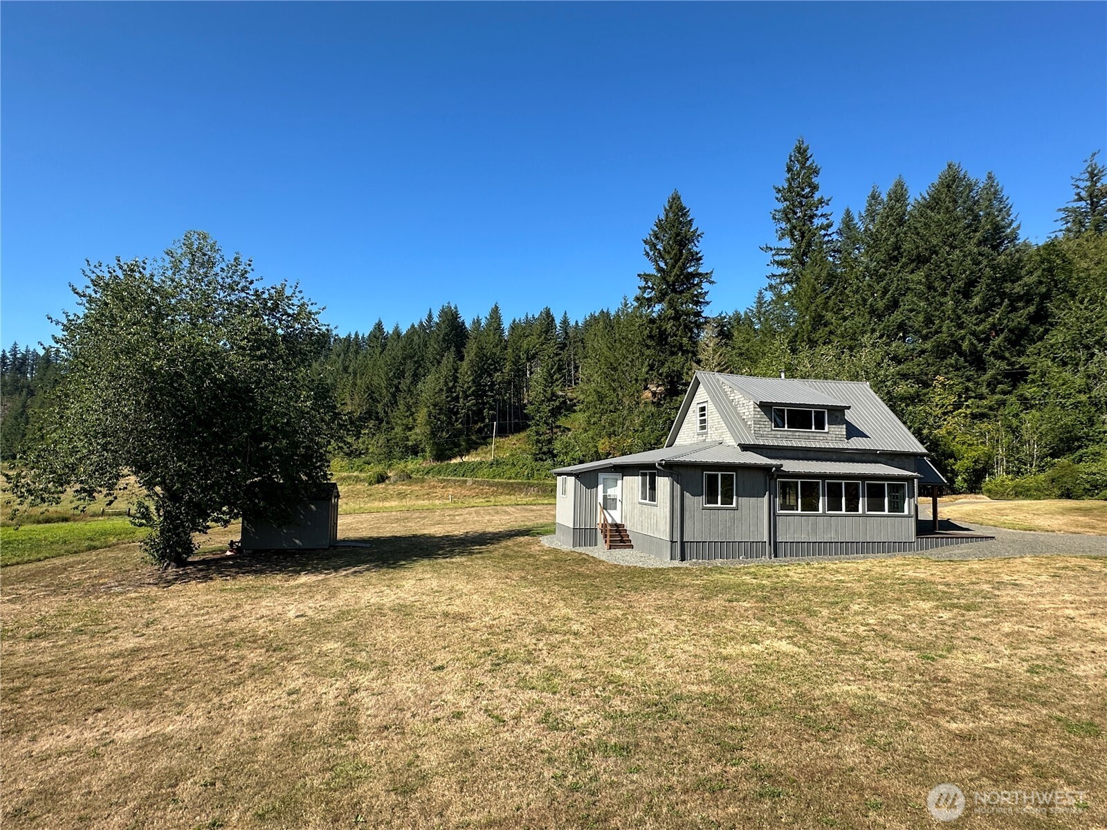 720 Leland Valley Road East Quilcene, WA 98376 - Photo 1 of 37 a front view of a house with a garden