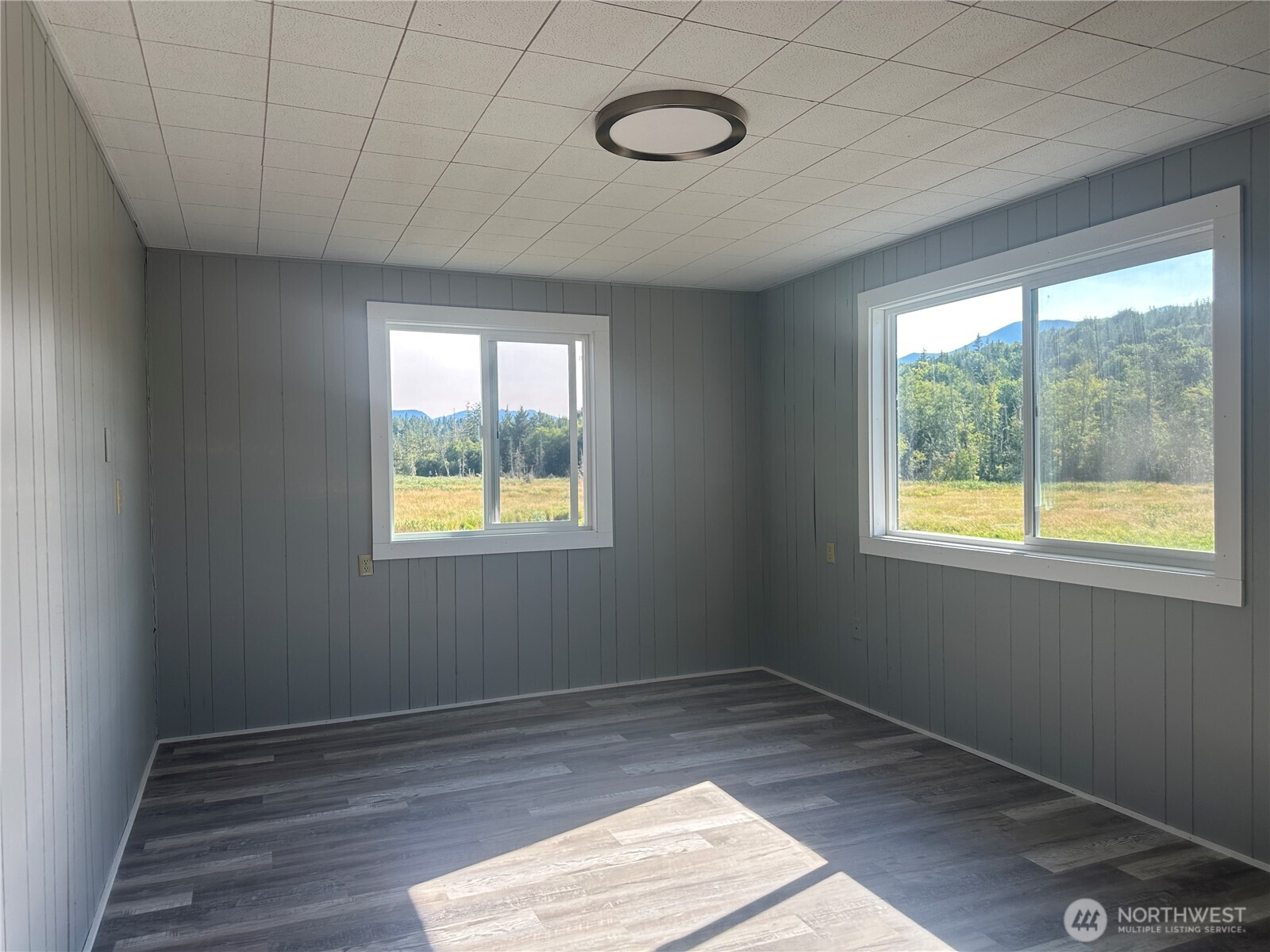 720 Leland Valley Road East Quilcene, WA 98376 - Photo 17 of 37 a view of an empty room with wooden floor and a window