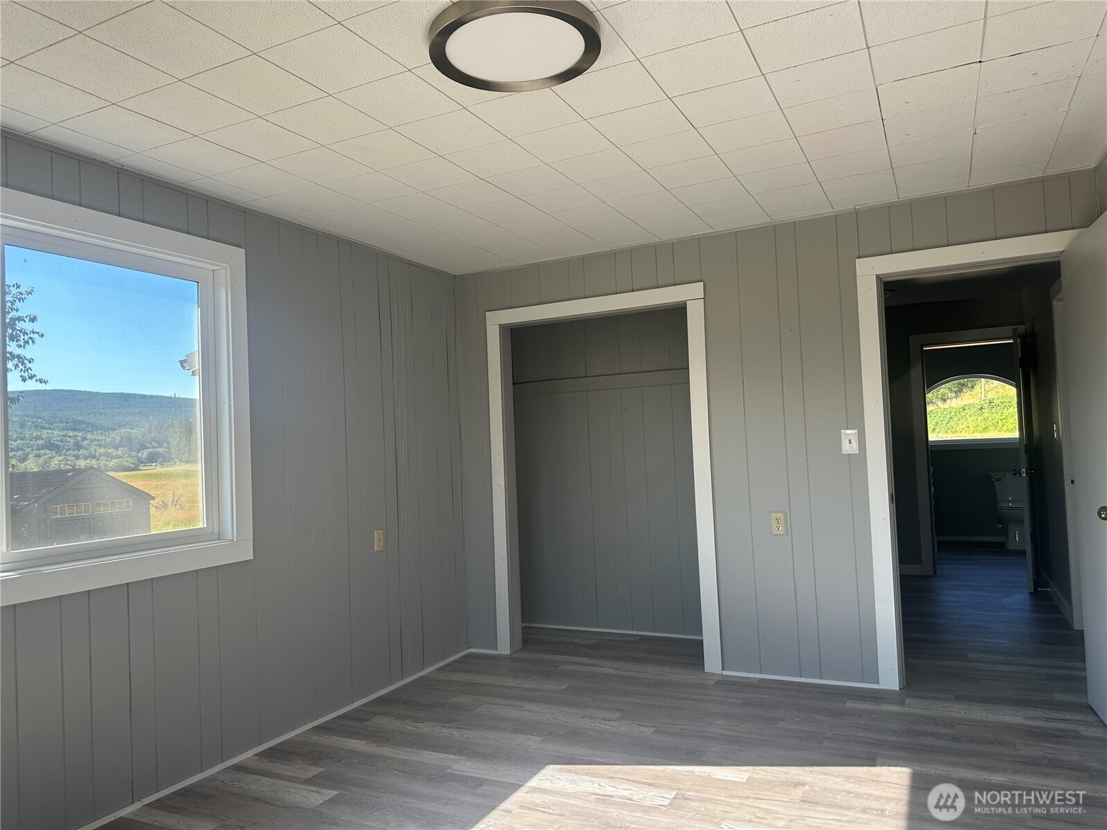 720 Leland Valley Road East Quilcene, WA 98376 - Photo 18 of 37 an empty room with wooden floor and windows