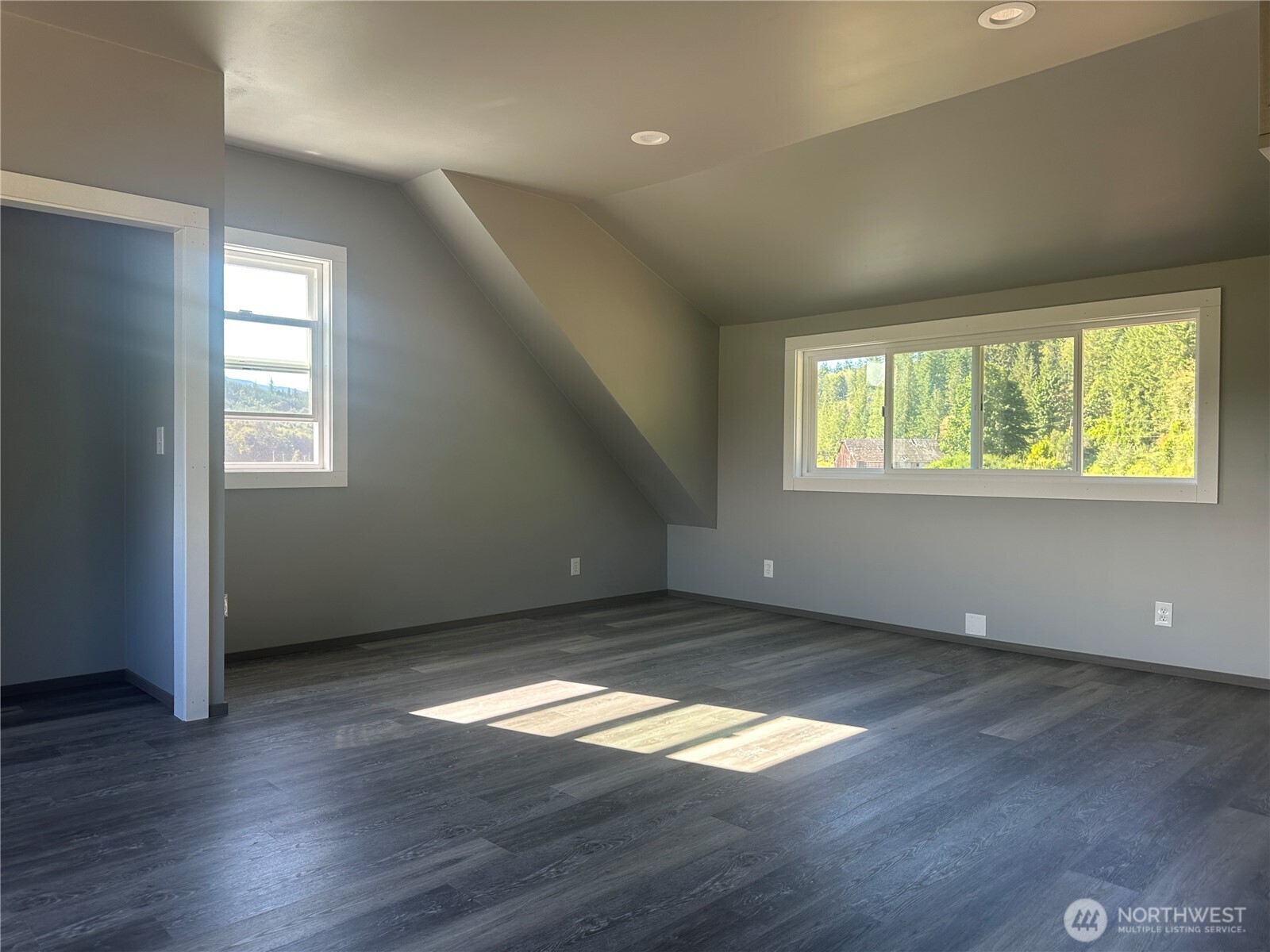 720 Leland Valley Road East Quilcene, WA 98376 - Photo 29 of 37 an empty room with wooden floor and windows