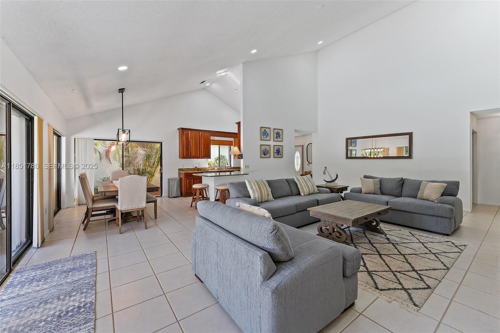 101 Sand Pine Drive, Unit 101 Jupiter, FL 33477 - Photo 11 of 33 a living room with furniture and a chandelier