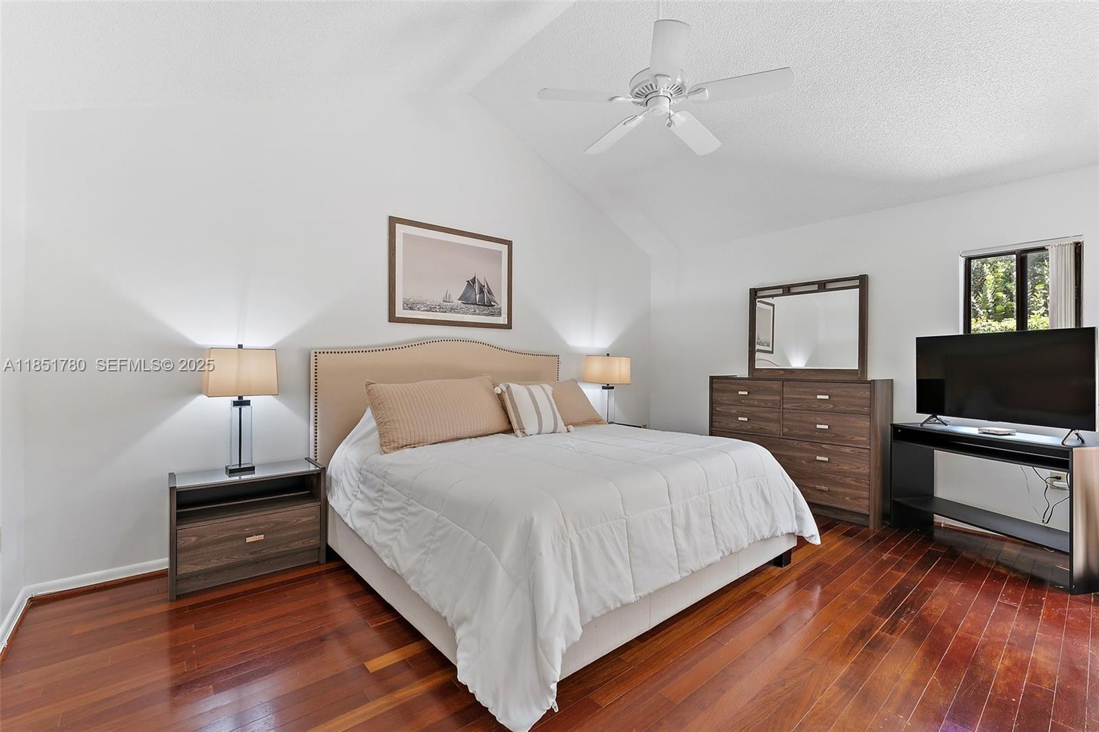 101 Sand Pine Drive, Unit 101 Jupiter, FL 33477 - Photo 14 of 33 a bedroom with a bed and a flat screen tv