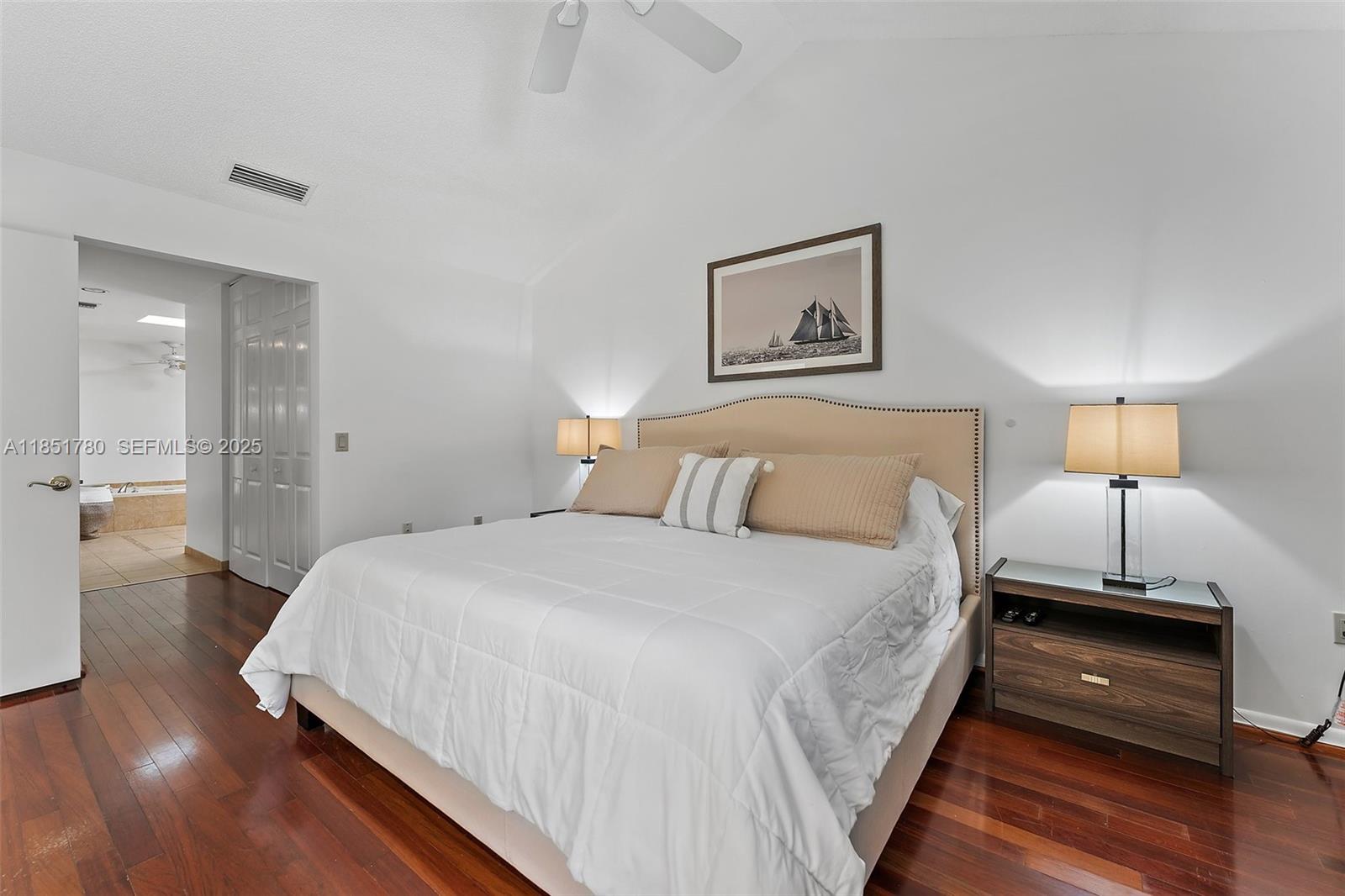 101 Sand Pine Drive, Unit 101 Jupiter, FL 33477 - Photo 16 of 33 a bedroom with a bed and a wooden floor