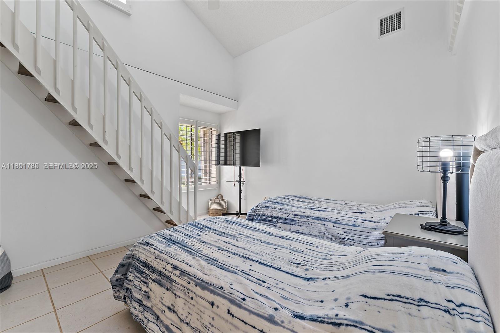101 Sand Pine Drive, Unit 101 Jupiter, FL 33477 - Photo 20 of 33 a view of a bedroom with wooden floor and stairs