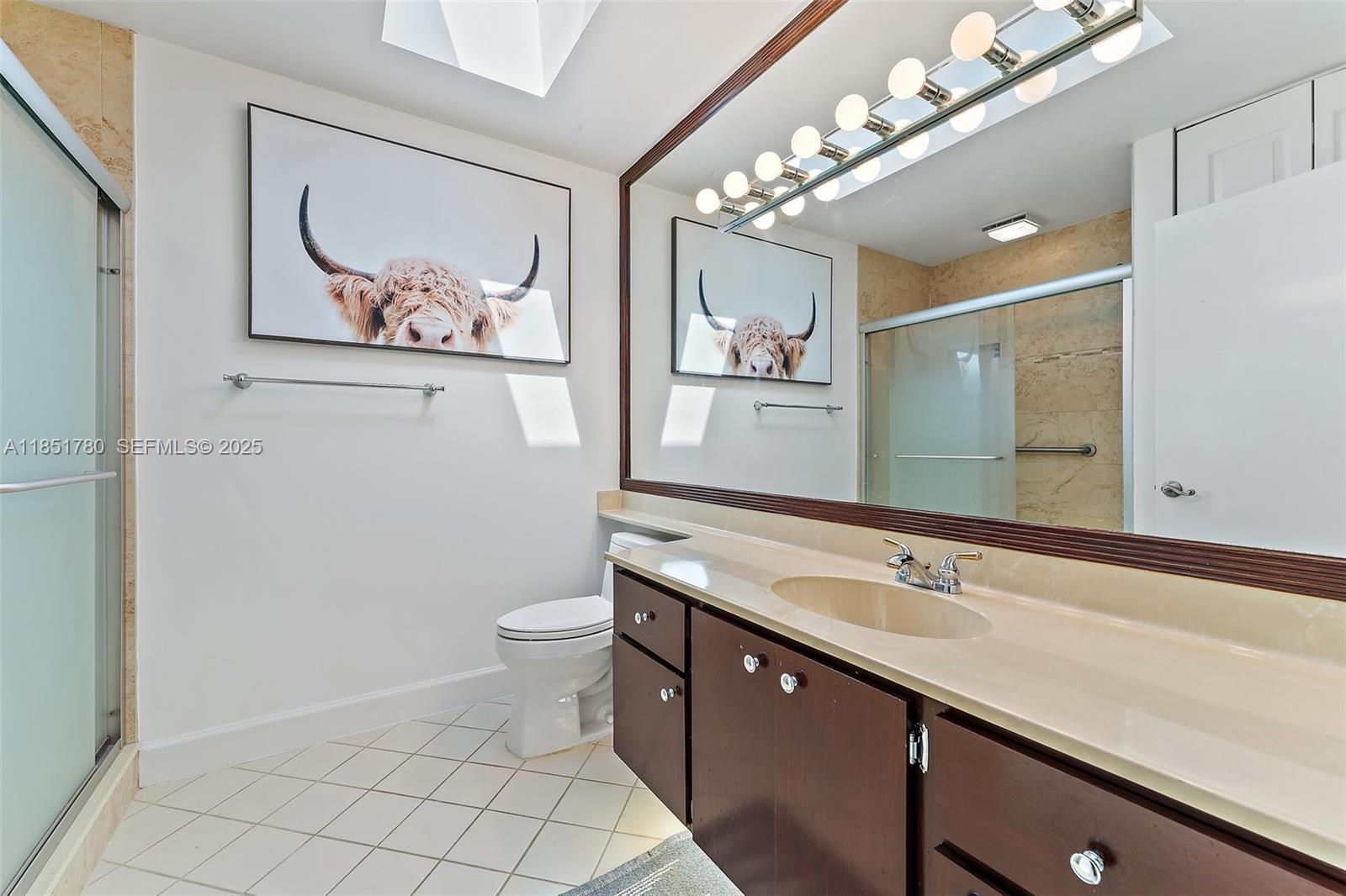 101 Sand Pine Drive, Unit 101 Jupiter, FL 33477 - Photo 23 of 33 a bathroom with a double vanity sink mirror and toilet