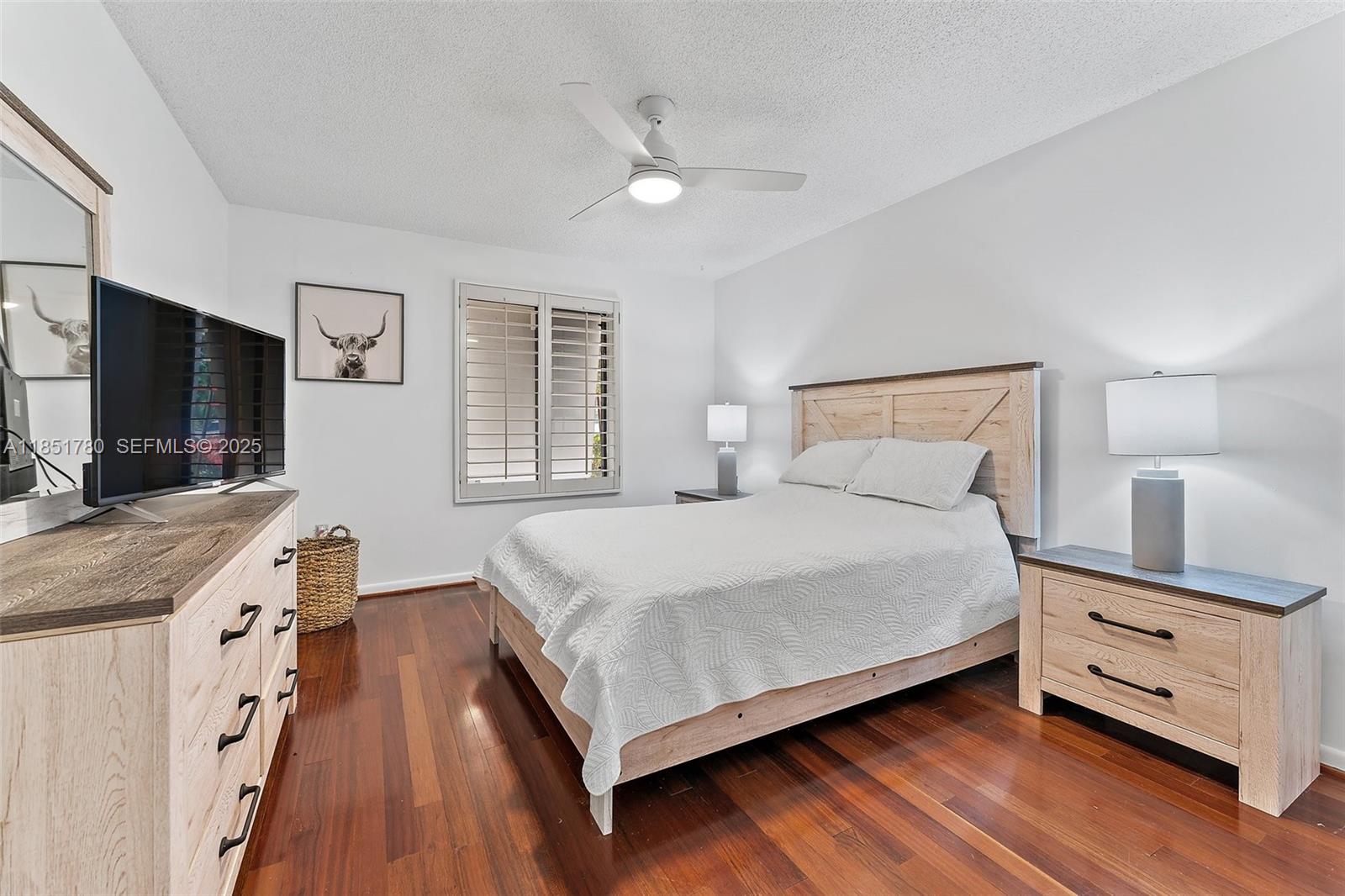 101 Sand Pine Drive, Unit 101 Jupiter, FL 33477 - Photo 24 of 33 a bedroom with a bed and a flat screen tv