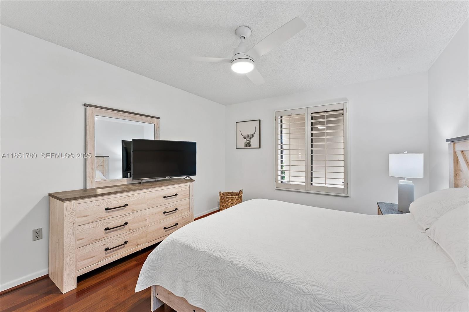 101 Sand Pine Drive, Unit 101 Jupiter, FL 33477 - Photo 25 of 33 a bedroom with a bed and flat screen tv