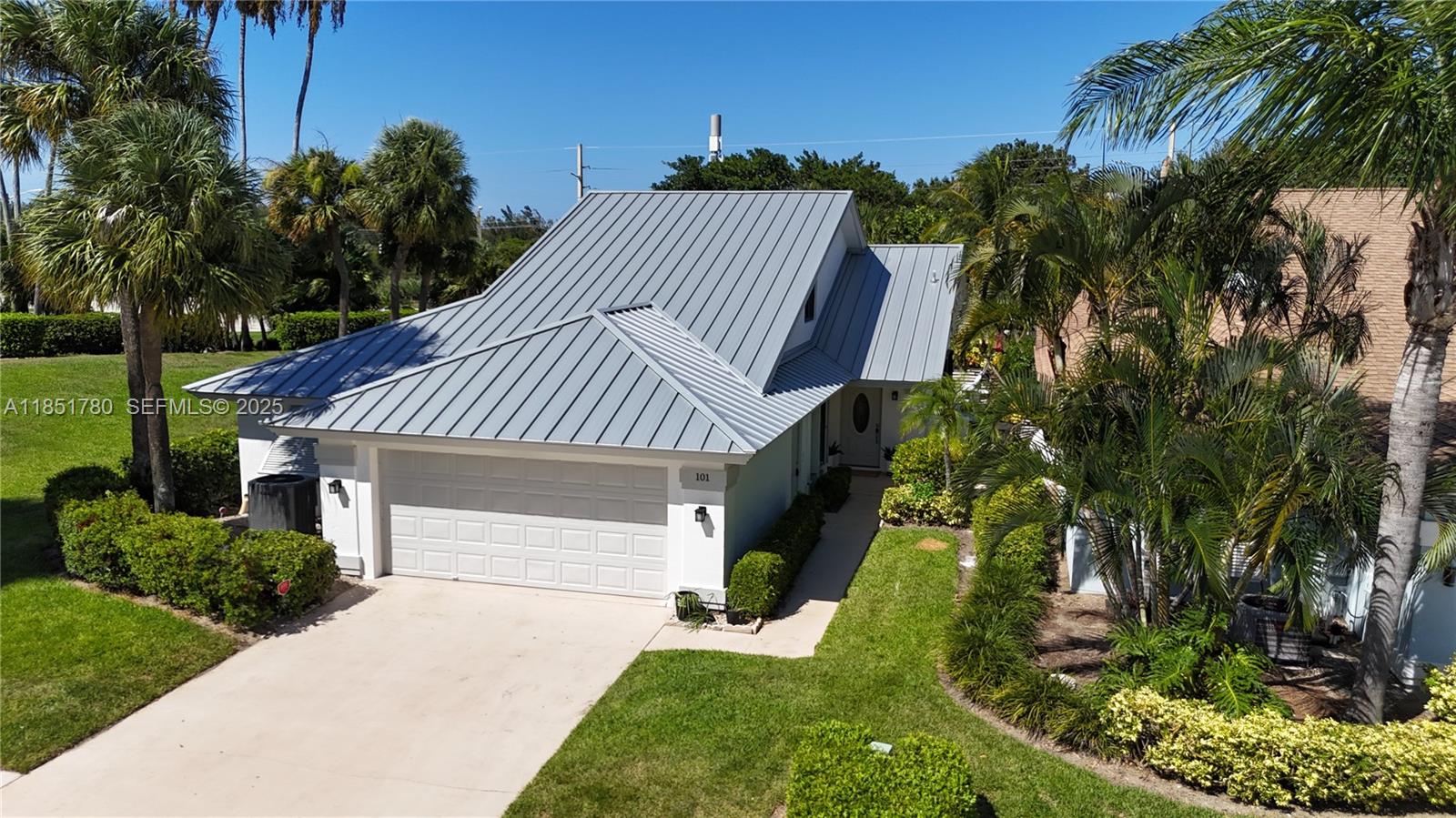 101 Sand Pine Drive, Unit 101 Jupiter, FL 33477 - Photo 3 of 33 a front view of a house with a yard