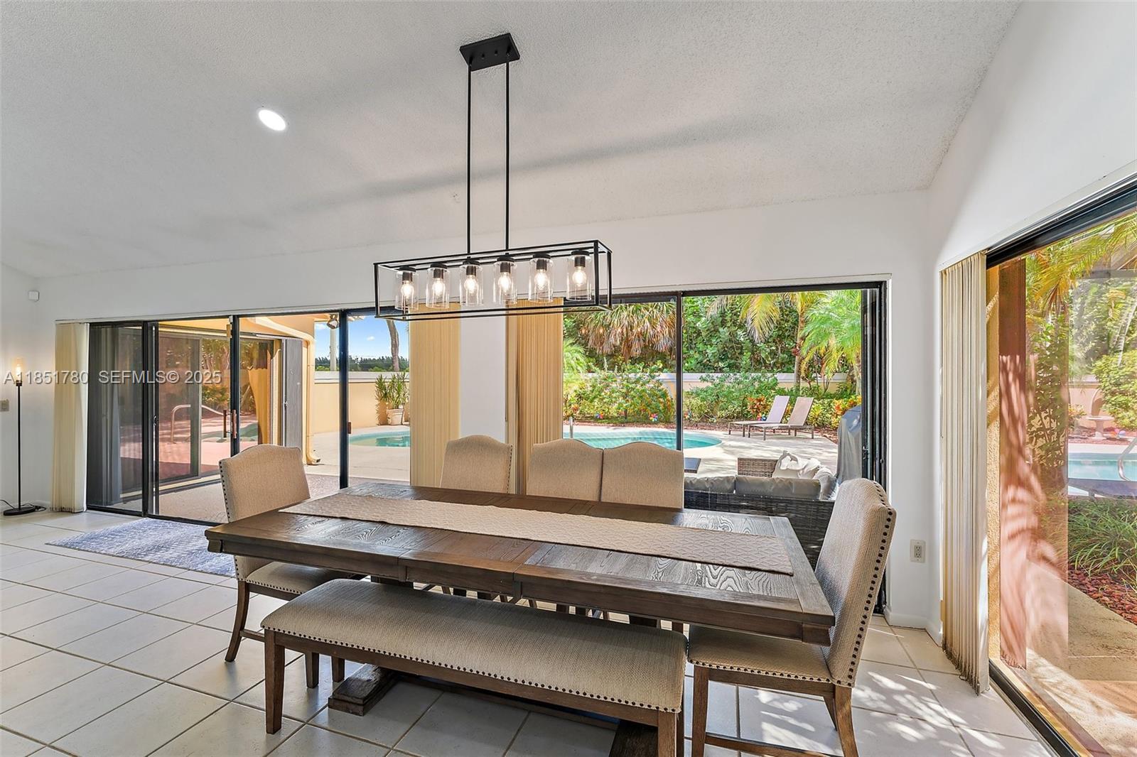 101 Sand Pine Drive, Unit 101 Jupiter, FL 33477 - Photo 8 of 33 a living room with furniture and a chandelier