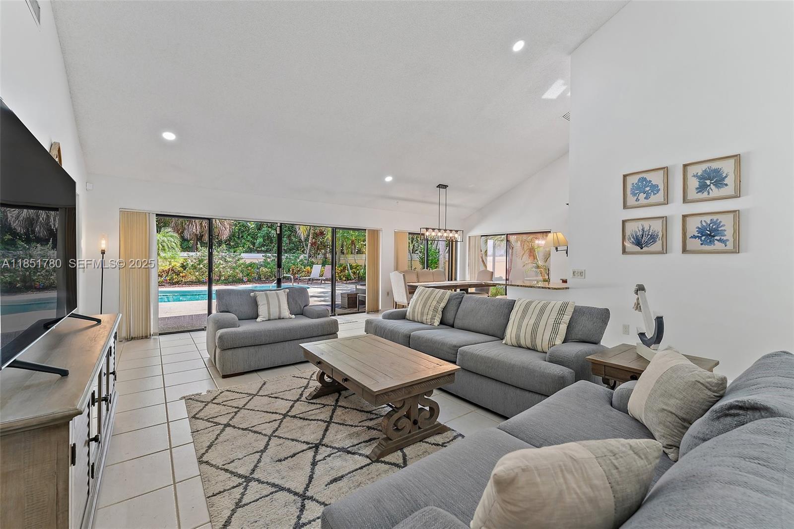 101 Sand Pine Drive, Unit 101 Jupiter, FL 33477 - Photo 10 of 33 a living room with furniture and a flat screen tv
