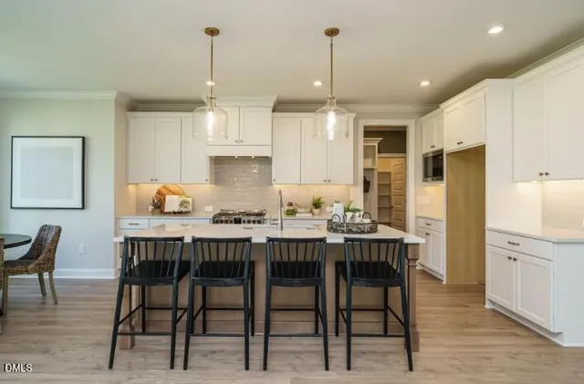 a kitchen with a dining table chairs sink and cabinets