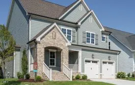 a view of a white house with yard and plants