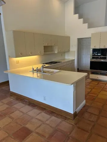 a kitchen with stainless steel appliances a sink a stove top oven a counter space and cabinets