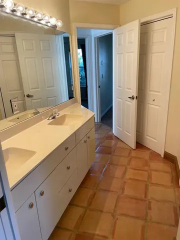 a spacious bathroom with a granite countertop sink a mirror and a